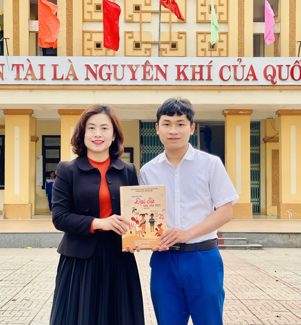Trần Đức Nhật Toàn  tặng tác phẩm dự thi  đạt giải nhất cuộc thi  “Đại sứ Văn hóa đọc”  cho cô giáo Nguyễn Thị  Thanh Nga  - Ảnh: NVCC